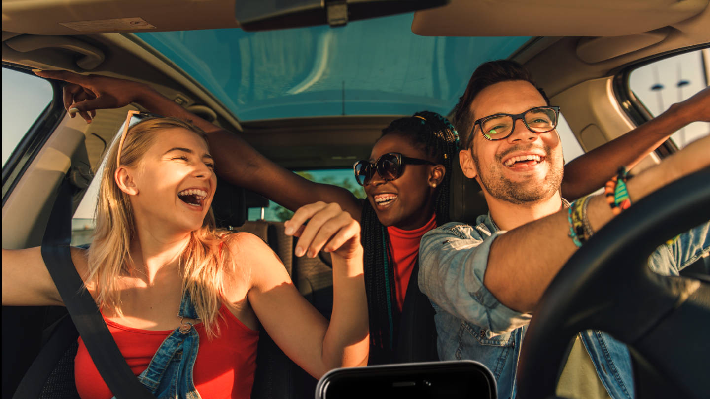 amis-qui-chantent-en-ecoutant-la-radio-en-voiture-sur-leur-smartphone